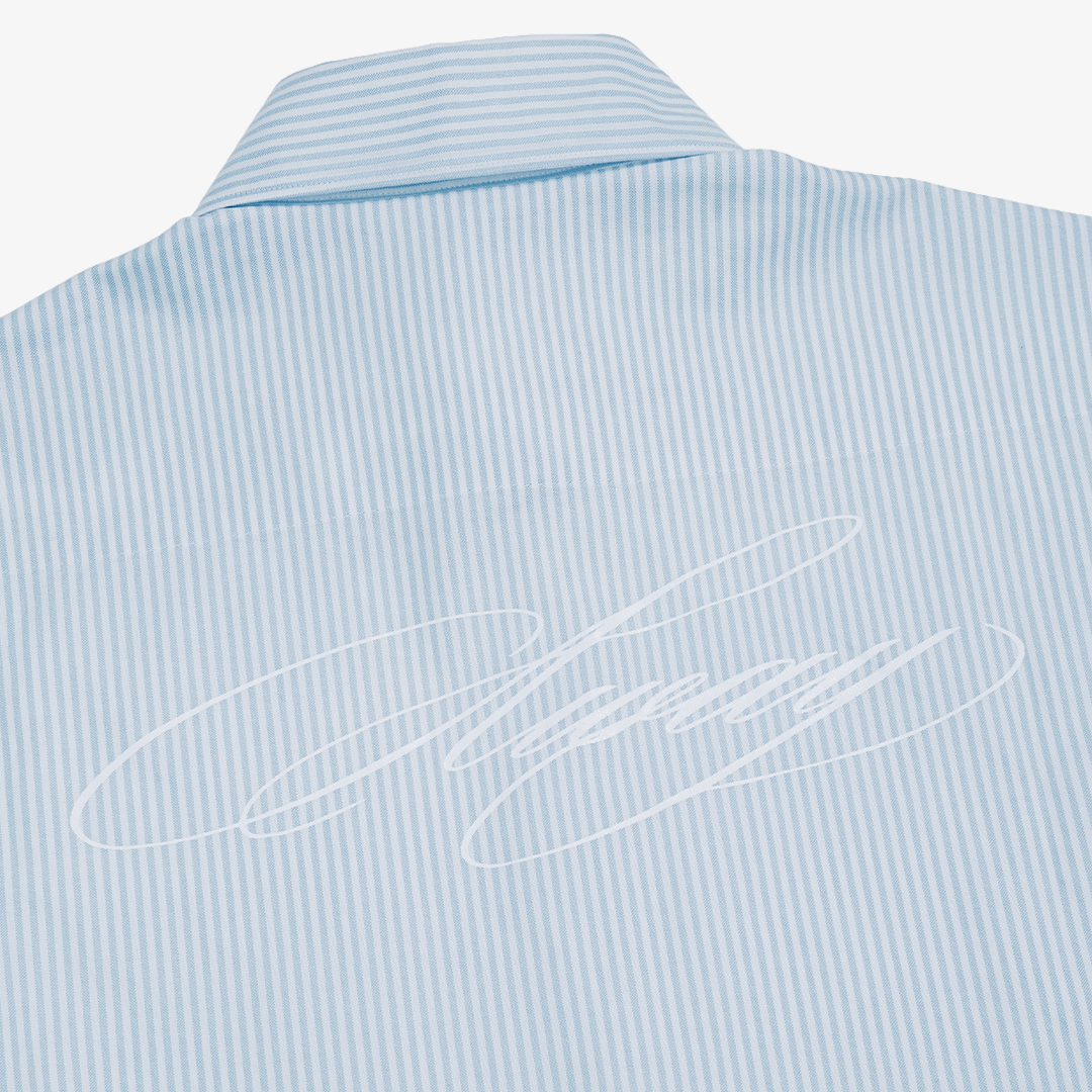 Close-up of the back of a light blue and white vertically striped dress shirt, featuring a white embroidered script logo across the center.