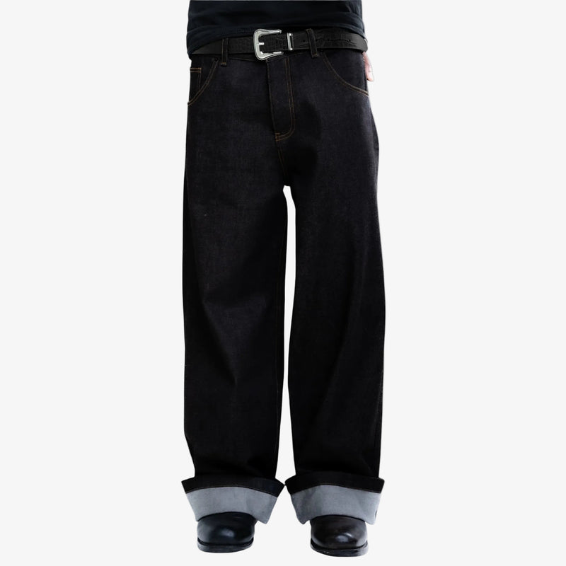 Black jeans with rolled-up cuffs  and black embossed belt on a white background