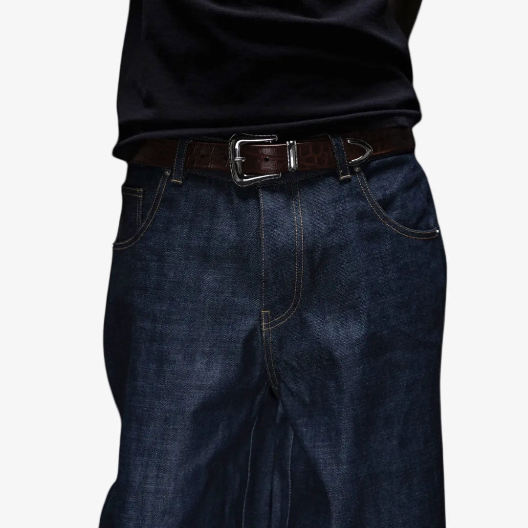 Dark blue jeans with a brown belt on a white background